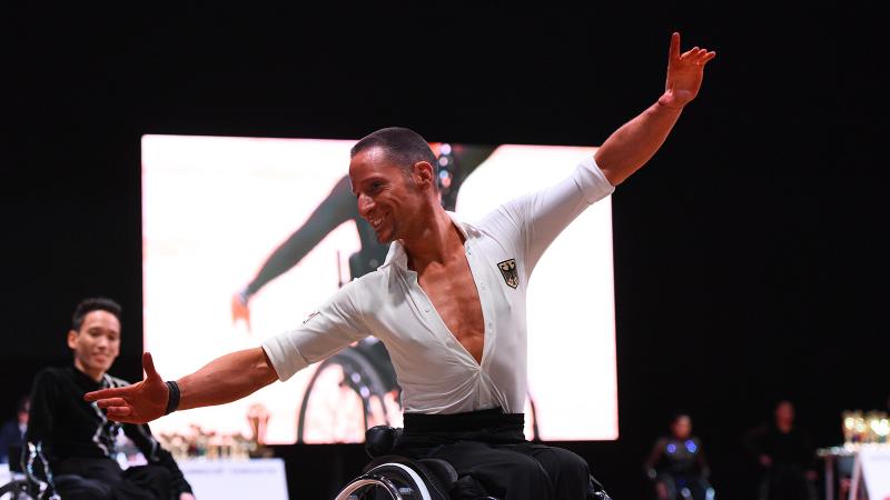 German male dancer spreads arms during performance