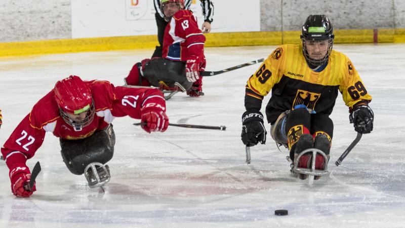 Two ice hockey players go for the puck