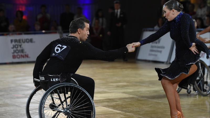 Man in wheelchair dances Latin with standing female partner