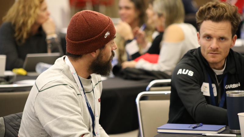 Two male athletes discussing at a workshop