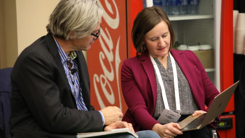 Two people looking at notes on a laptop