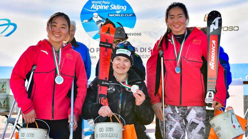 Three female sit-skiers on the podium