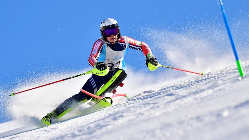 Male standing skier makes a turn