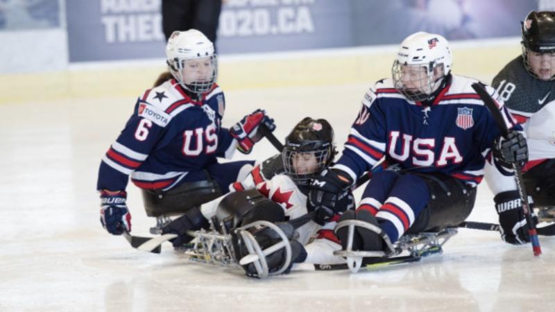 US and Canadian female Para ice hockey players fight for the puck