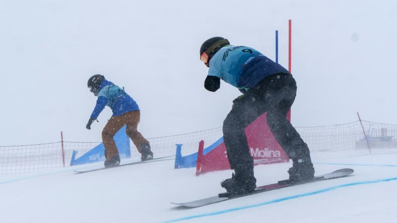 Two Para snowboarders competing side by side