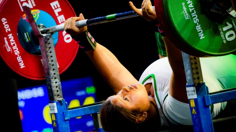 A female Para powerlifter preparing to lift the bar