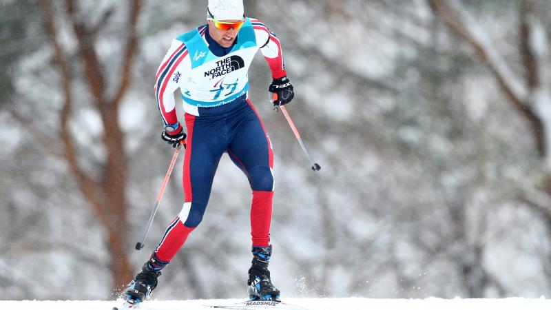 Norwegian male standing skier competes in biathlon