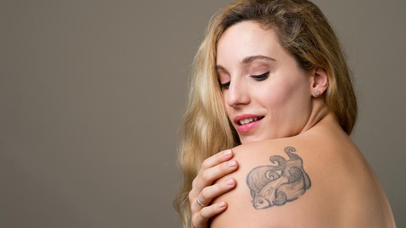 A woman showing the tattoo near her shoulder