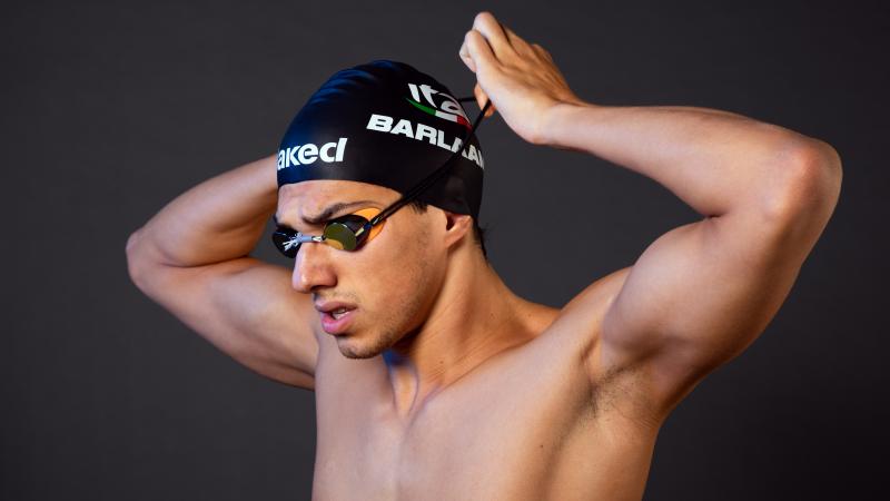 A male swimmer adjusting his swim cap