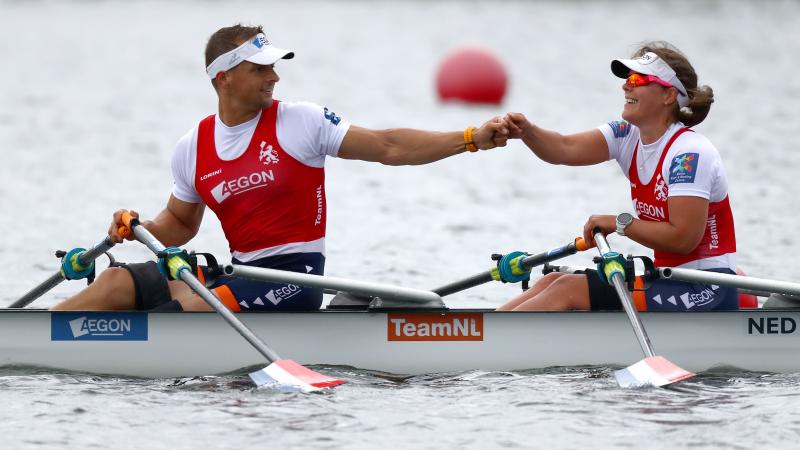 Male and female Dutch rowing duo give each other a fist bump