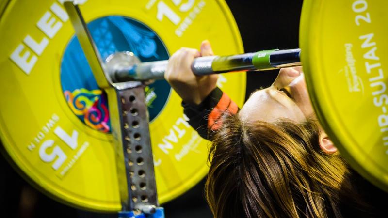 A female powerlifter preparing to lift the bar 