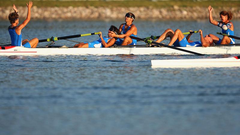 Italian mixed coxed four crew celebrate in exhaustion after winning gold