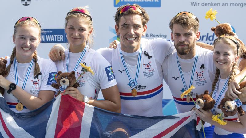 British mixed coxed four squad posing happily on the podium together