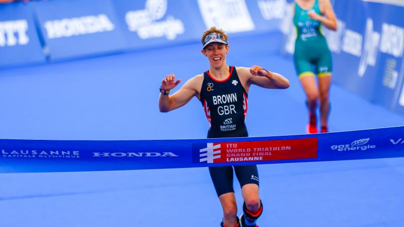 British female Para triathlete celebrates before she crosses the finish line