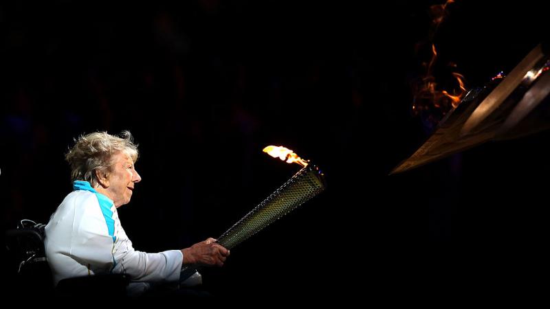 Older female woman in wheelchair lighting cauldron of Paralympic Games