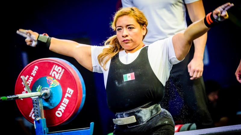 A woman stretching her arms before competing in a powerlifting bench press