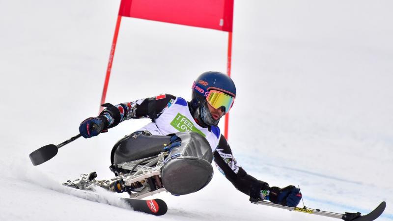 A male sit-skier competing on a giant slalom event