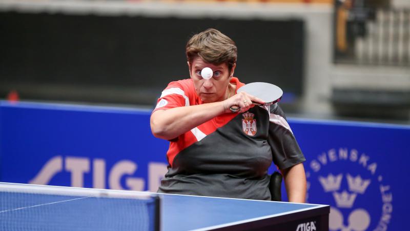 Female table tennis player in wheelchair returns a shot