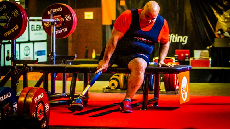 A man on a bench press in a Para powerlifting competition