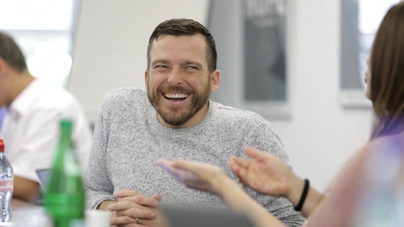 Man in wheelchair laughing during a meeting