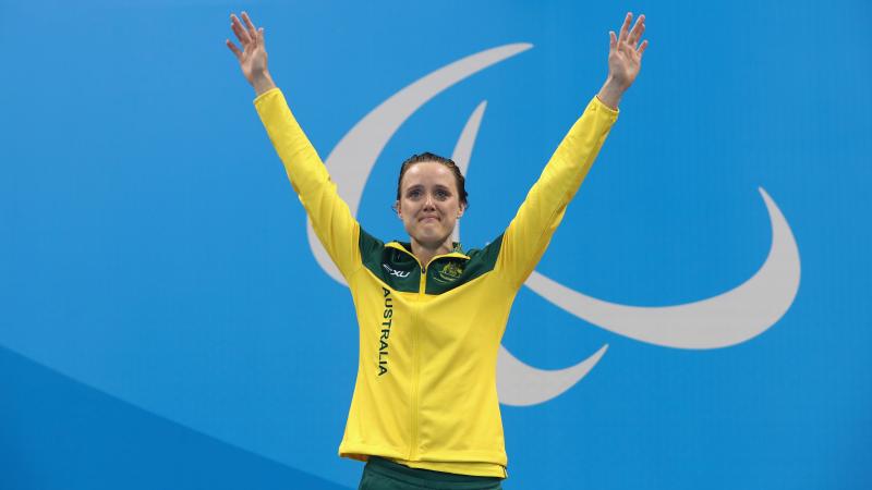 Ellie Cole lifts her arms while standing on the Paralympic podium in Rio