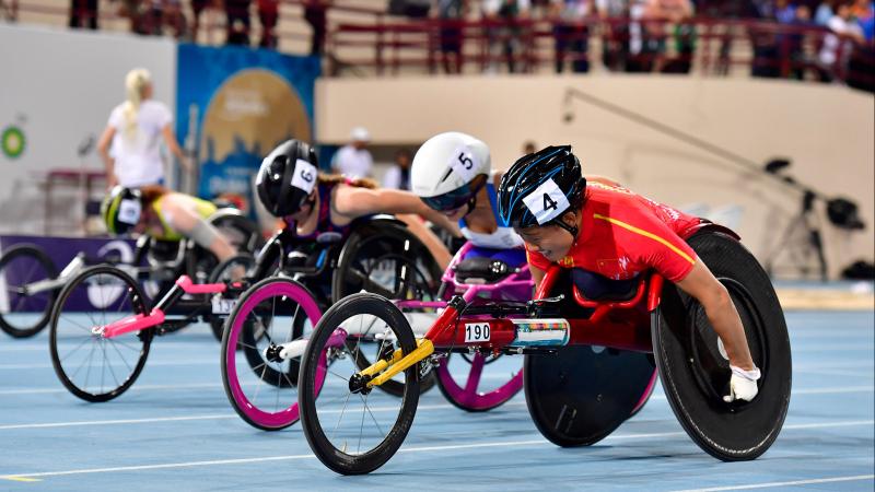 Four female wheelchair racers racing on the track