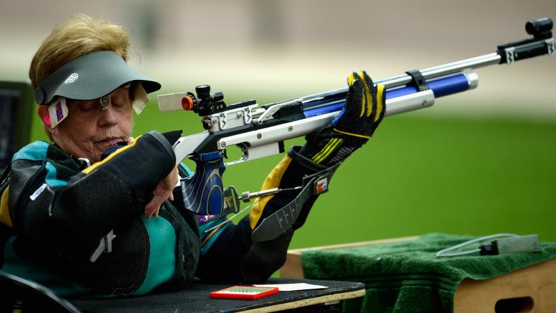 A woman competing with a rifle in a shooting range