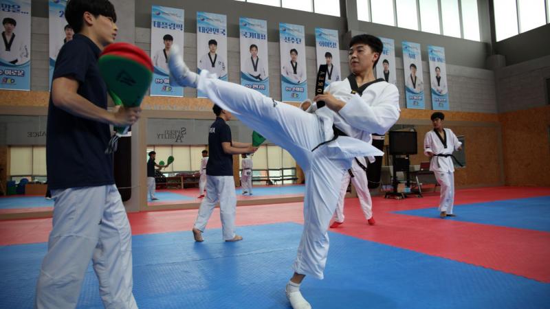 Korean taekwondo athlete kicks during training
