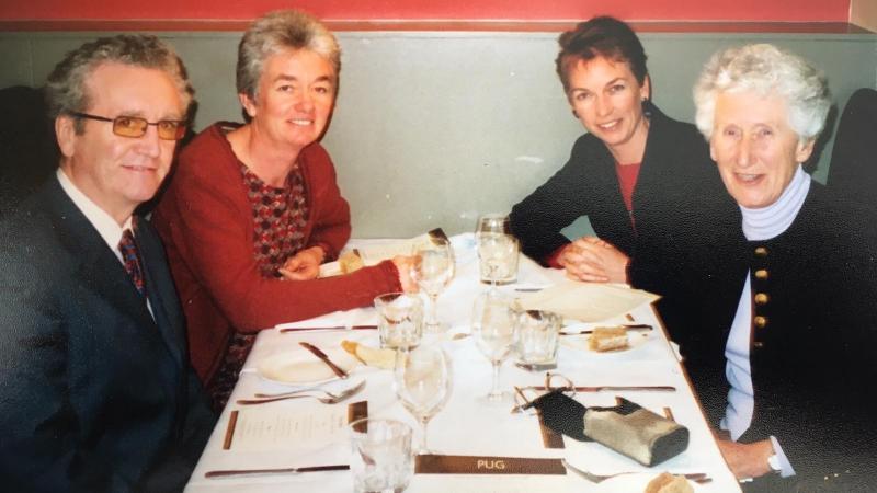 Photo of four people at a restaurant table smiling for a photo