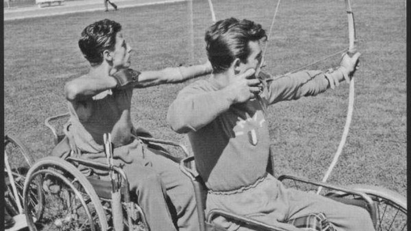 Two male archers in wheelchairs competing in archery - black and white photo from 1960