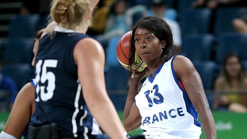 Female wheelchair basketball player defended strongly by her opponent