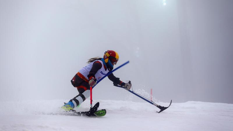 A leg amputee female Para alpine skier competing