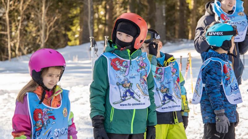 Four children and a man on the snow