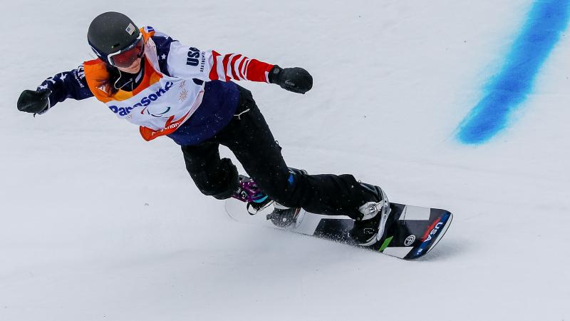 A female snowboarder with a prosthetic leg competing