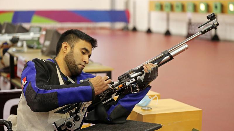 A man loading a rifle in a shooting range