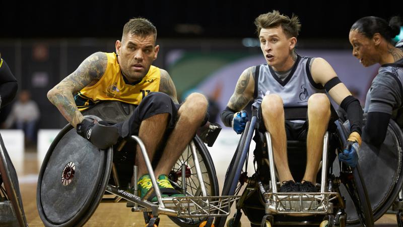 Two male wheelchair rugby players competing on the court