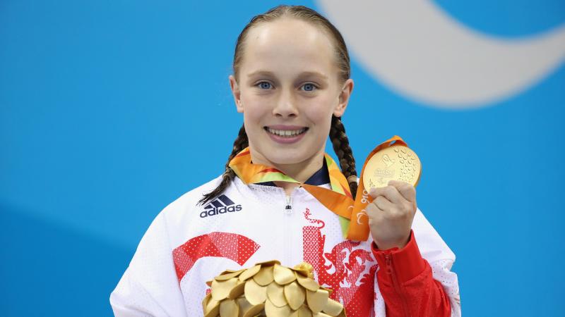 British female swimmer smiling with gold medal