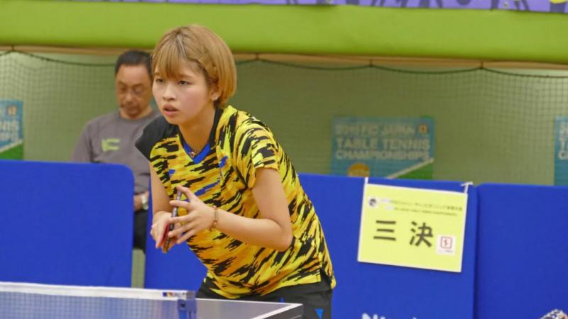 Kanami Furukawa holding her racket while waiting her rival to serve