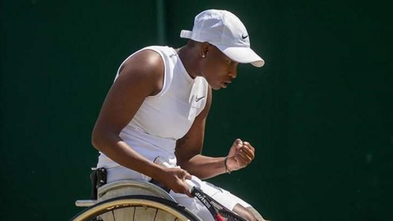 Black female wheelchair tennis player celebrates a point