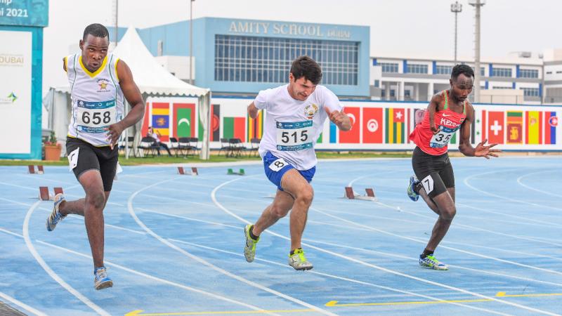 Tajikistan's Faizullo Shukrulloi running sprint race alongside two athletes