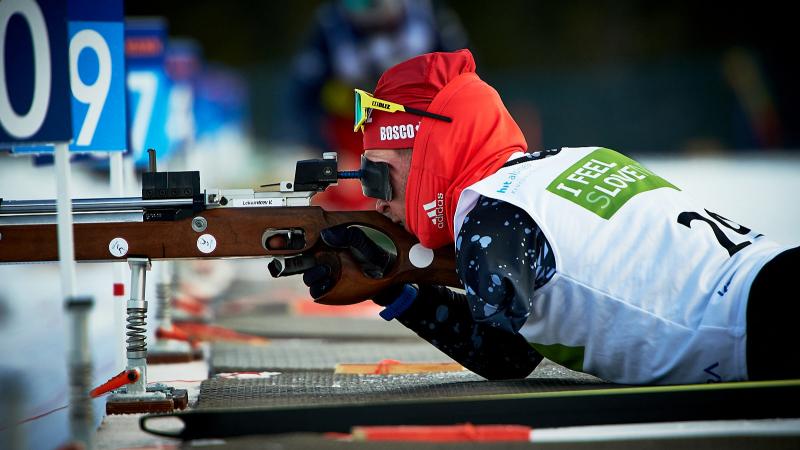 A men without the left arm shooting with a rifle during a Para biathlon competition