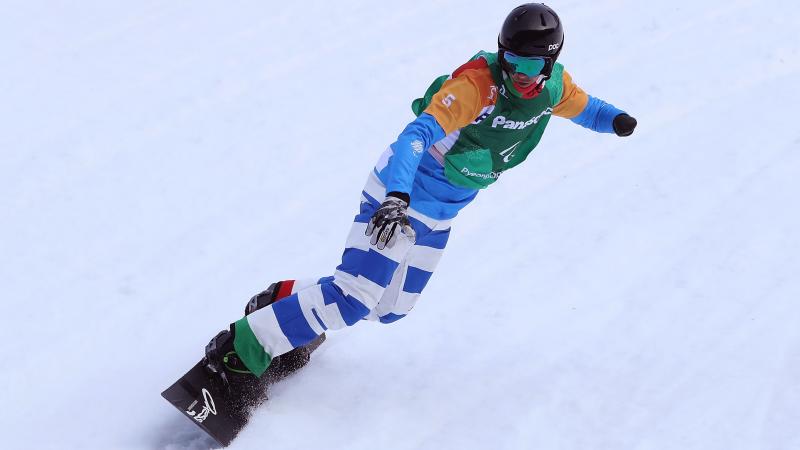 An one-armed man competing in a snowboard event 