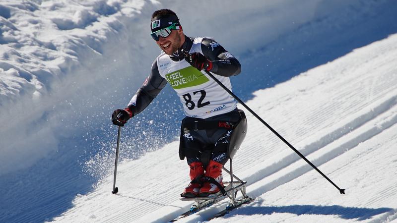 A man in a sit skiing competing in a cross-country event in the snow