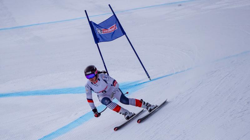 A female Para alpine skier competing in a downhill race