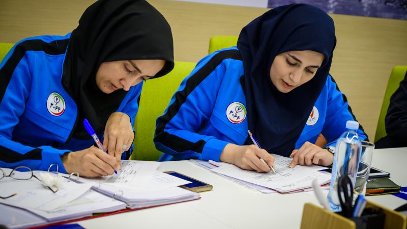 Two women taking notes