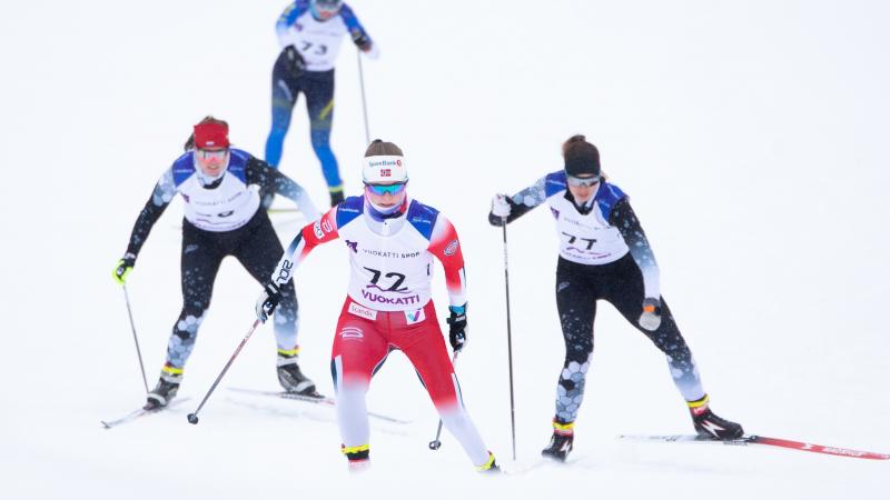 Vilde Nilsen competing in Nordic skiing race being followed by three rivals