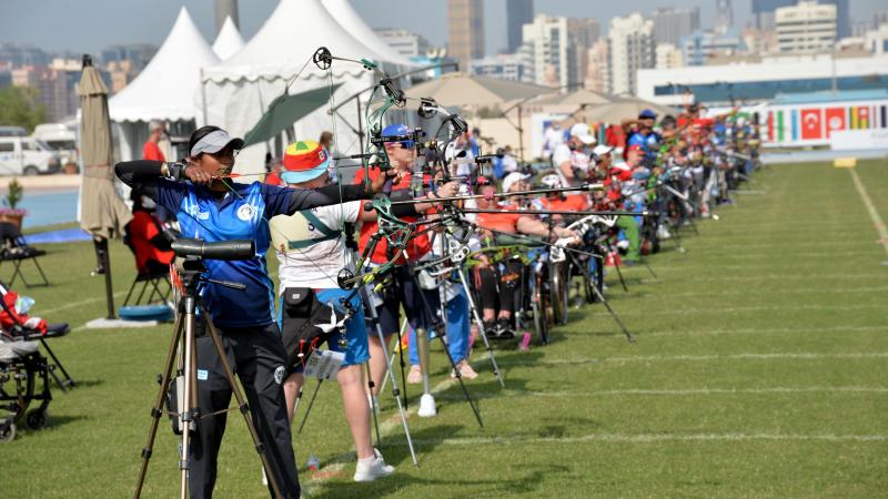 Female Para archers lined up preparing to shoot