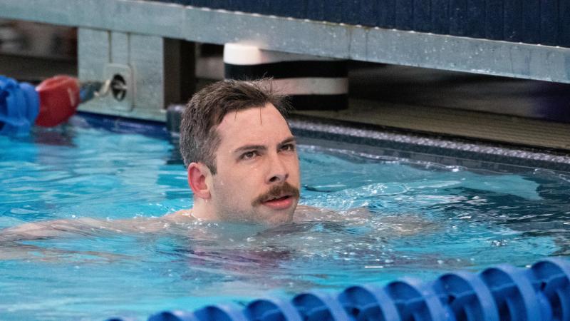 A male swimmer with a moustache in the swimming pool