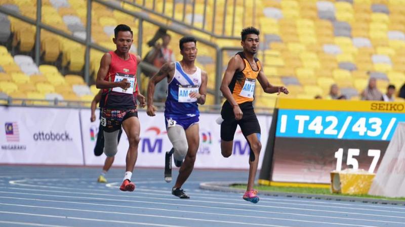 Three Asian men sprinting to the finish line