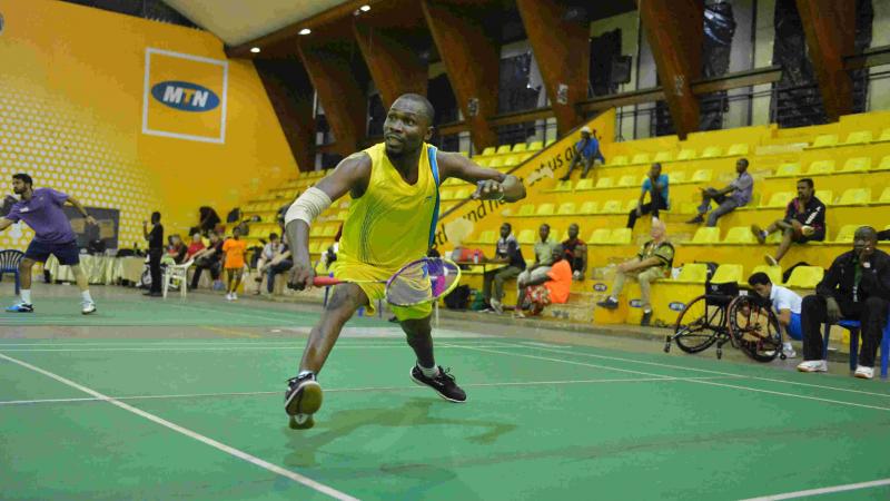 Nigerian man reaches to return the shuttle in badminton